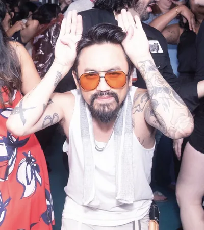 Tinypants in orange shades with hands up like ears